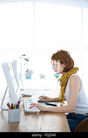 Hipster réfléchie businesswoman se concentrant sur son ordinateur Banque D'Images