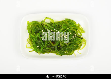 Partie de l'avidité traditionnelle Asiatique salade d'algues marinées entrée sur petit plat blanc Plaque sur fond blanc, vue du dessus Banque D'Images