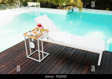 Plateau avec petit-déjeuner en table et chaise longue Banque D'Images