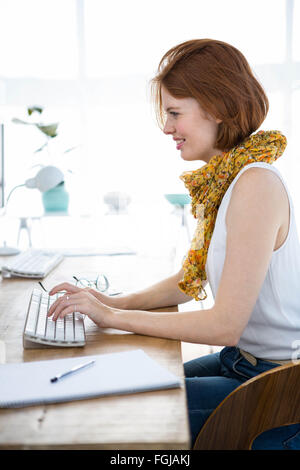 Hipster smiling businesswoman de taper sur son ordinateur Banque D'Images