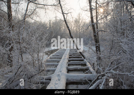 Vieux pont en bois couvert de neige en hiver Banque D'Images