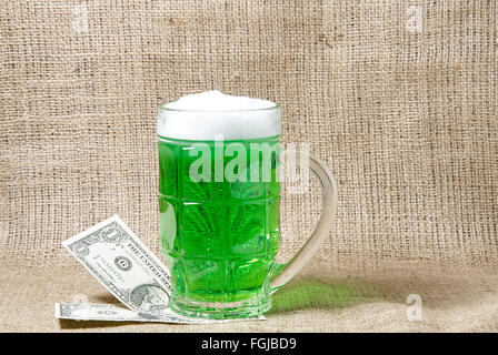 Verre de bière verte irlandaise et de dollars sur une toile de fond. Symboles traditionnels de la Saint-Patrick. Place pour le texte Banque D'Images