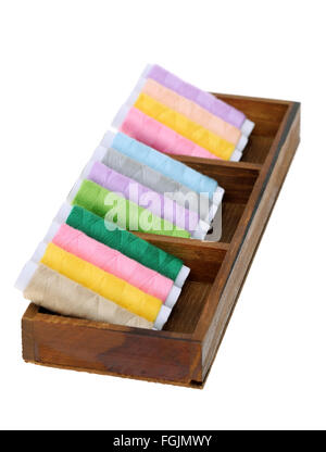 Collection de fils colorés dans une boîte en bois isolé sur fond blanc Banque D'Images