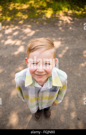 Jeune garçon à l'extérieur dans un style de portrait en lumière naturelle. Banque D'Images