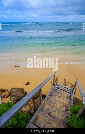 Les escaliers mènent à une plage sur la côte nord d'Oahu Hawaii où les clients peuvent louer des maisons et rester dans une ambiance tropicale parad Banque D'Images