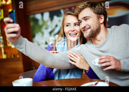 Jeune couple amoureux faisant en selfies cafe Banque D'Images