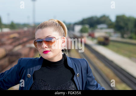 Le portrait de femme dans des rails de chemin de fer contre les lunettes Banque D'Images