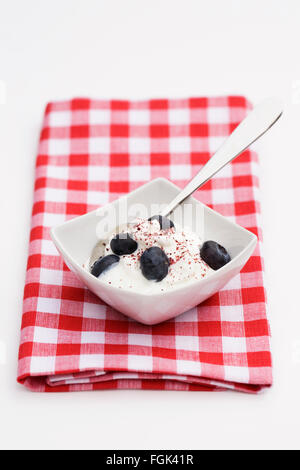 Skyr surmontée de bleuets et de canneberge en poudre. Banque D'Images