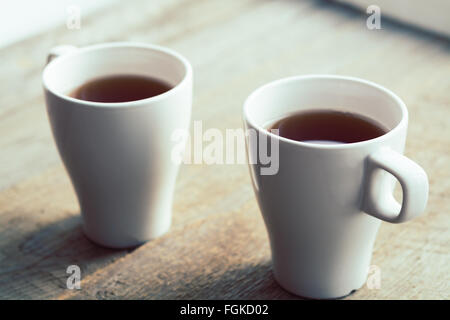 Deux tasses blanc sur la vieille table en bois. Format horizontal. Selective focus, tonique Banque D'Images