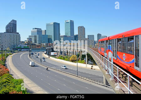 Canary Wharf DLR skyline train quitte la gare Est de l'Inde dans les Docklands de Londres & traverse Aspen Way à deux voies vers Canary Wharf Banque D'Images