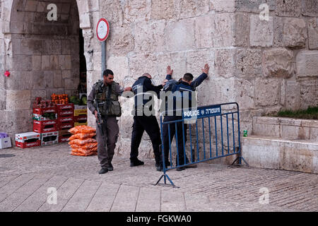 Des policiers israéliens body-check un jeune Palestinien à l'entrée de la porte d'Hérode aussi Bab el Zahra à l'extérieur de la vieille ville de Jérusalem Israël Banque D'Images