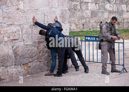 Des policiers israéliens body-check un jeune Palestinien à l'entrée de la porte d'Hérode aussi Bab el Zahra à l'extérieur de la vieille ville de Jérusalem Israël Banque D'Images