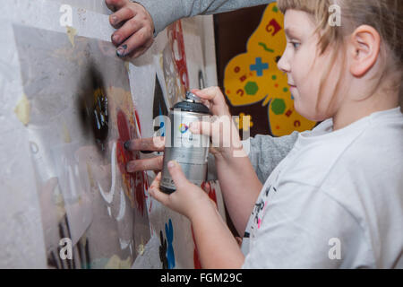 Jozefow, Pologne - 24 octobre 2015 : La fille avec la couleur peinture par pulvérisation peinture murale Banque D'Images