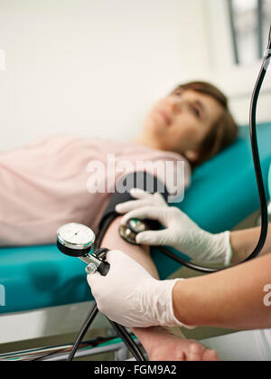 Infirmière la mesure de pression artérielle du patient, Autriche Banque D'Images