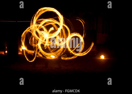 Le feu et le feu pétille de traces de feu dansant sur la plage prise en utilisant la technique d'exposition longue. Banque D'Images