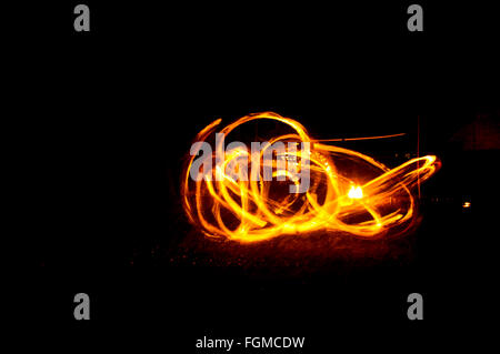 Le feu et le feu pétille de traces de feu dansant sur la plage prise en utilisant la technique d'exposition longue. Banque D'Images