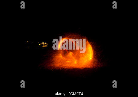 Le feu et le feu pétille de traces de feu dansant sur la plage prise en utilisant la technique d'exposition longue. Banque D'Images