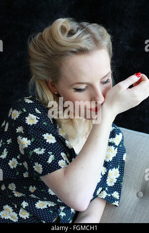 1940 woman smelling perfume sur son poignet Banque D'Images