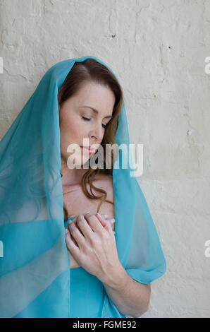 Jolie femme mature avec un foulard mains sur coeur Banque D'Images