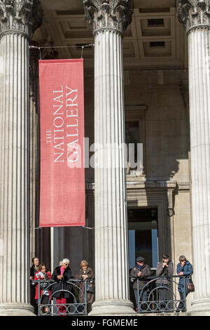 Les touristes à la recherche sur Trafalgar Square à partir de l'entrée de la National Gallery de Londres Banque D'Images