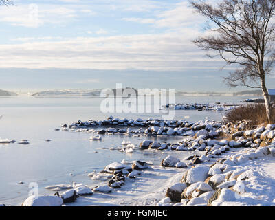 Journée d'hiver ensoleillée idyllique sur la rive du Hafrsfjord à Stavanger en Norvège, la couverture de glace et de neige , paysage blanc bleu calme Banque D'Images