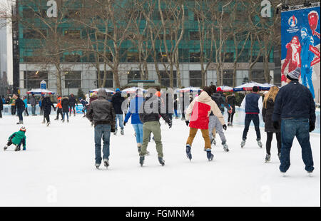 Les personnes bénéficiant de la patinoire en plein air libre de la neige à la Bank of America l'hiver Village de Bryant Park, New York Banque D'Images