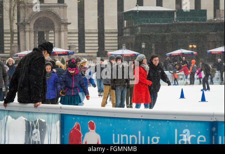 Les personnes bénéficiant de la patinoire en plein air libre de la neige à la Bank of America l'hiver Village de Bryant Park, New York Banque D'Images