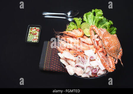 Mixte de fruits de mer avec sauce épicée nourriture thaïe isolés traditionnels sur noir Banque D'Images