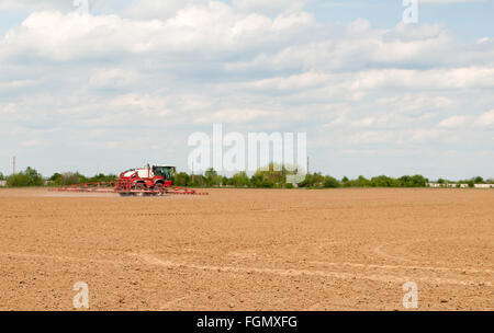 Un pulvérisateur enjambeur sur un champ dans un paysage de prairie Banque D'Images