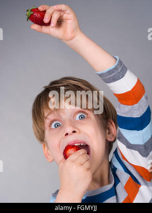 Boy eating strawberries Banque D'Images