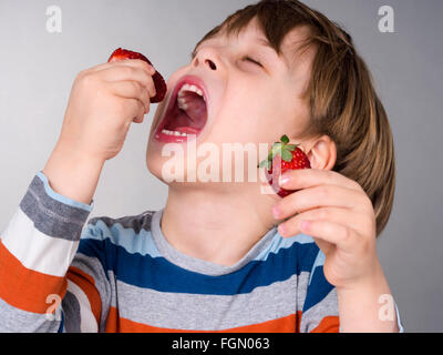 Boy eating strawberries Banque D'Images