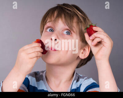 Boy eating strawberries Banque D'Images