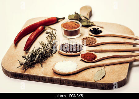 Diverses épices colorées sur plus de cuillères de cuisine table en bois grunge Banque D'Images