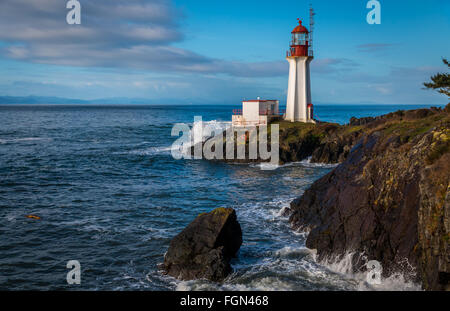 Shearingham phare sur l'île de Vancouver, Colombie-Britannique Canada comme des vagues de l'océan Pacifique rouler à terre. Banque D'Images