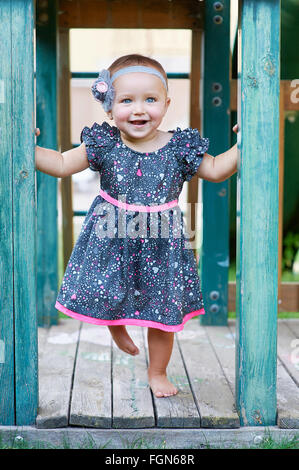 Beautiful smiling cute little girl sur une aire de jeux Banque D'Images