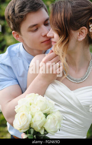 Mariée et le marié baiser dans le jardin au printemps Banque D'Images