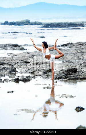 Une jeune femme latine en blanc pratiquant le yoga sur la plage de Santa Teresa - un endroit célèbre pour son bien-être, la péninsule de Nicoya, Costa Rica Banque D'Images