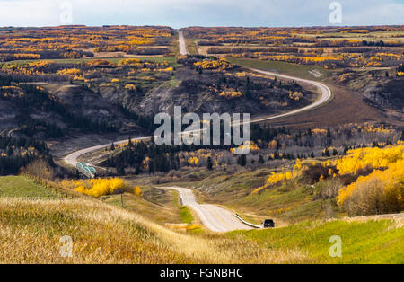 La route serpente dans une prairie d'une vallée aux couleurs de l'automne dans les Badlands du centre de l'Alberta Canada Banque D'Images