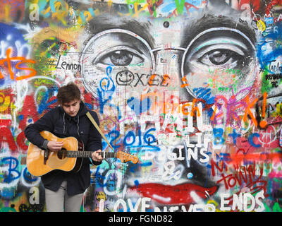 Jeune homme jouant de la guitare en face de mur de Lennon à Prague, République Tchèque Banque D'Images