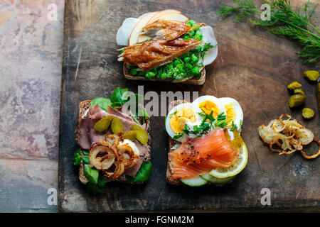 Les sandwiches ouverts scandinave avec le maquereau, le saumon fumé et d'oeufs et le rôti de bœuf et d'oignon croustillant Banque D'Images
