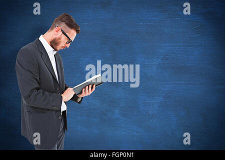 Image composite de geeky jeune homme de la lecture du livre noir Banque D'Images