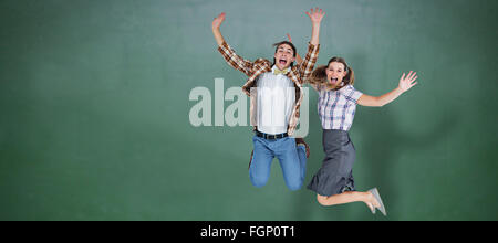 Image composite de geeky hipsters jumping and smiling Banque D'Images