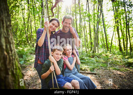 Portrait smiling family à corde swing en bois Banque D'Images