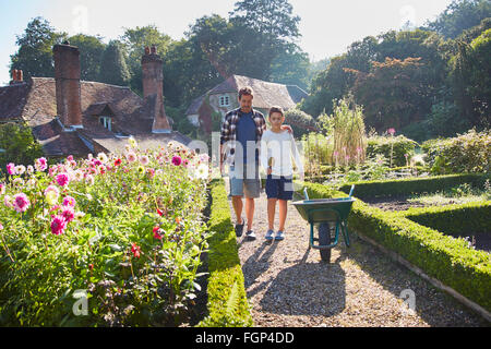 Le père et le fils marchant dans le jardin ensoleillé Banque D'Images