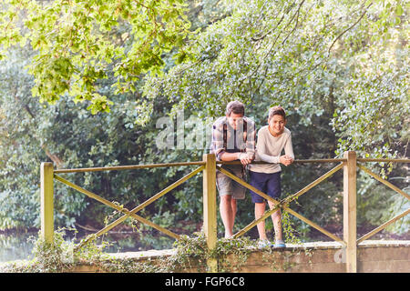 Père et fils sur la passerelle en parc avec des arbres Banque D'Images