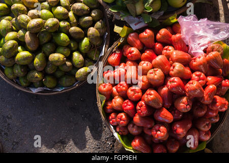 Des paniers remplis de rose tropical fruits d'avocat d'apple et sous la lumière du matin sur le marché de rue, au Vietnam. Banque D'Images