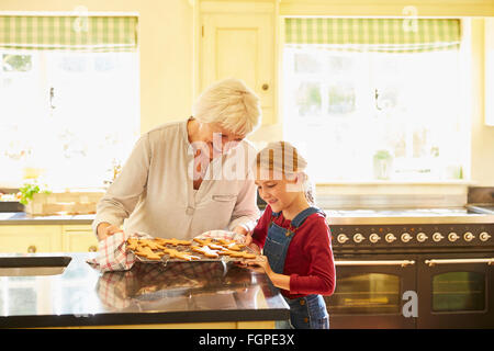 Grand-mère et petite-fille de gingerbread cookies in kitchen Banque D'Images