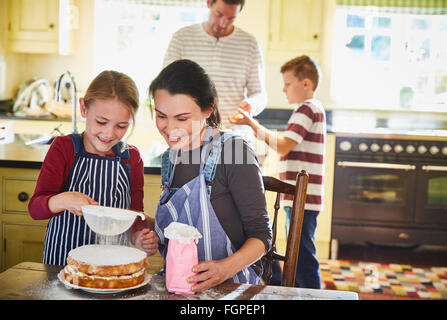 Family baking cake in kitchen Banque D'Images