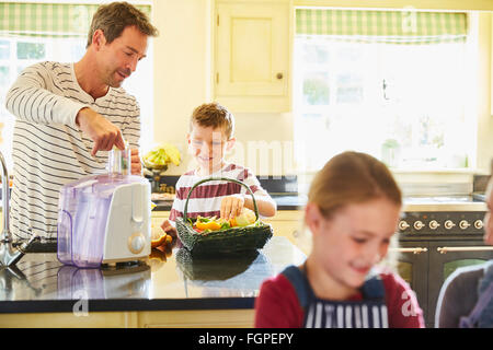 Père et fils un jus de légumes dans la cuisine Banque D'Images