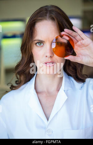 Opticien sérieux holding up lens Banque D'Images